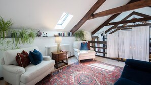 A loft-style living room with exposed wooden beams, a skylight, a patterned rug, and two sofas. - 1 Bed in Tavistock (oc-96009) (Cudlipptown)