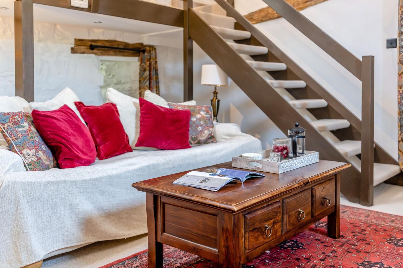 A living room with a sofa, coffee table, and a staircase.