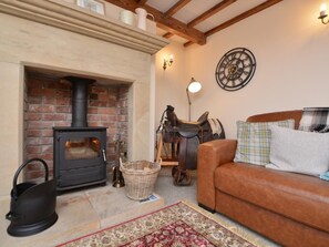 A cozy living room with a fireplace, a leather sofa, a patterned rug, and a wall-mounted clock. - 2 Bed in Matlock (oc-75893) (Slaley)