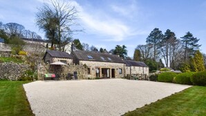 A stone building with a gravel driveway, surrounded by greenery and trees. - 2 Bed in Matlock (oc-75893) (Slaley)