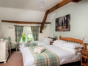 A bedroom with two beds, a dresser, a painting of a forest, and a window with curtains. - 2 Bed in Brecon (oc-bn178) (Llanfihangel Nant Bran)