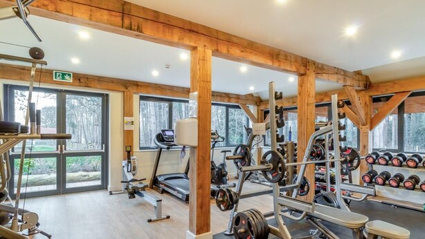 Una palestra con attrezzature per sollevamento pesi, tapis roulant e manubri.