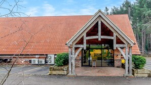 Un edificio con tetto in tegole rosse, ingresso in legno e condizionatori d'aria esterni.