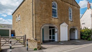 A stone building with arched doorways and a single visible window. - 2 Bed in Beaminster (oc-78567) (Beaminster)