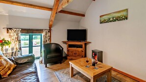 Un soggiorno con divano, tavolo in legno, televisore e camino.