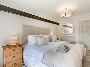 A bedroom with a bed, bedside lamp, dresser, and a round mirror on the wall. - 5 Bed in Halifax (oc-96061) (Sowerby Bridge)