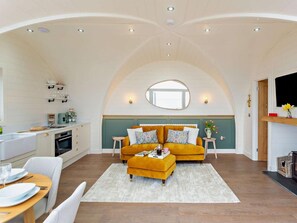 A cozy interior with a sofa set, a dining area, and a kitchen.