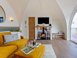A cozy living room with a sofa, a coffee table, and a fireplace.