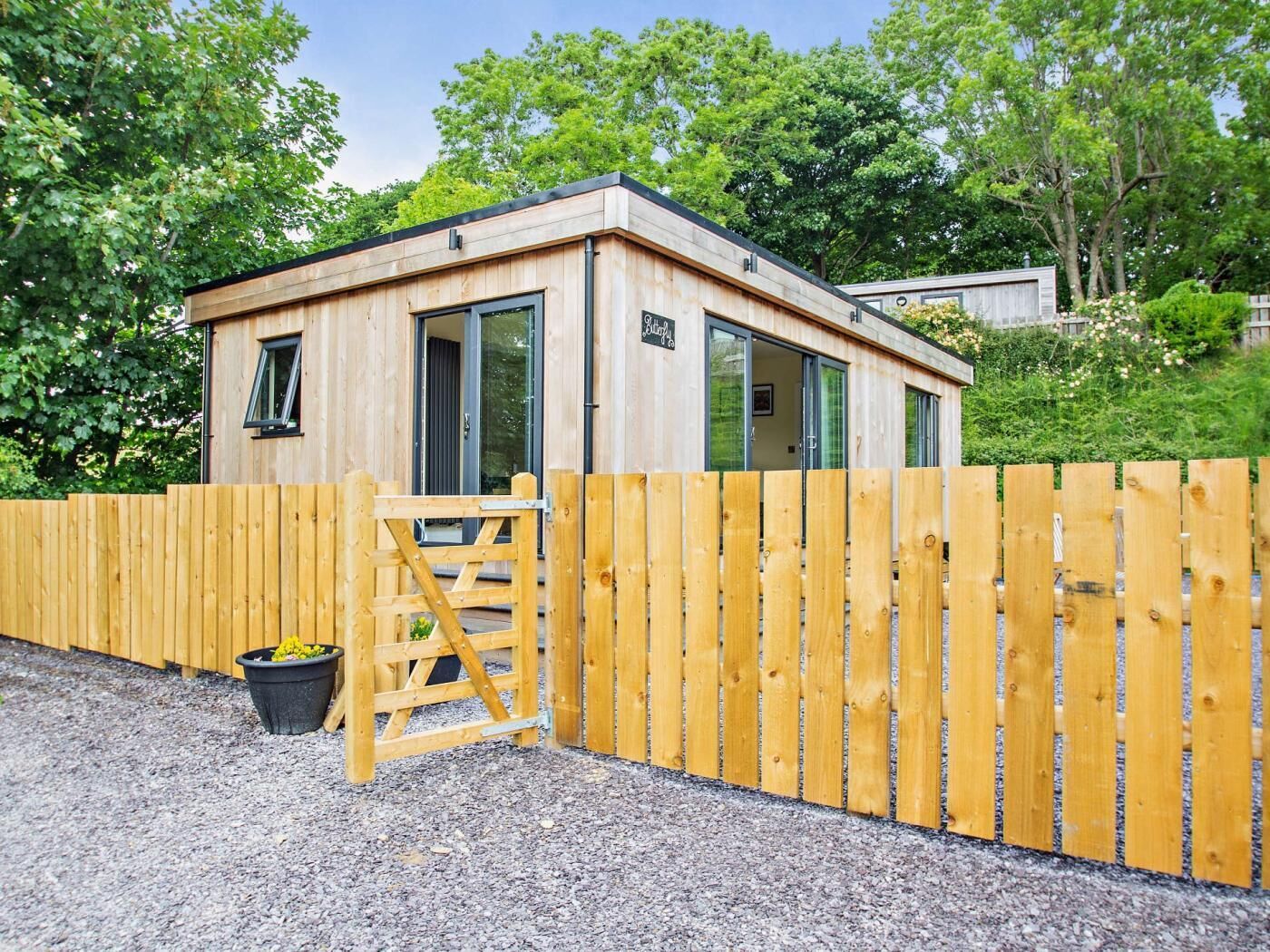 Une cabane en bois avec une porte, une fenêtre et une petite pancarte.