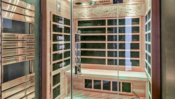 A sauna with multiple benches, glass doors, and a wooden interior. - 3 Bed in Shanklin (oc-92053) (Shanklin)