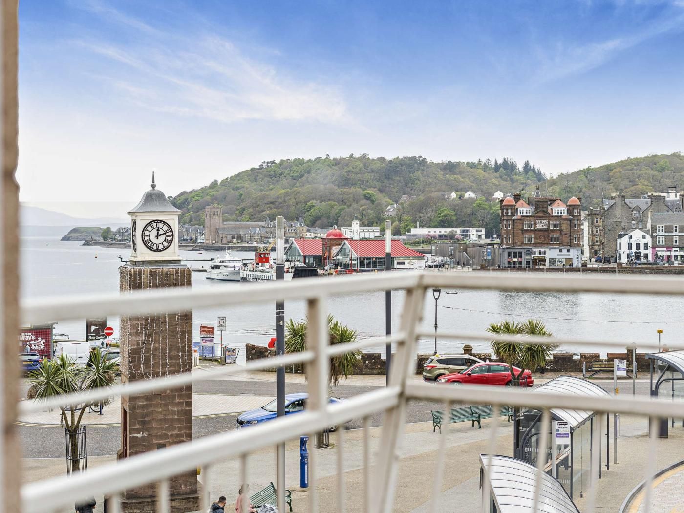 A waterfront view with a clock tower, buildings, and a bridge.