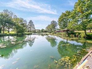 A serene lakeside setting with a row of cabins and a dock extending into the water. - 3 Bed in Cullompton (oc-96118) (Willand)