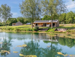 A lakeside property with a house, a dock, and a small boat. - 3 Bed in Cullompton (oc-96118) (Willand)