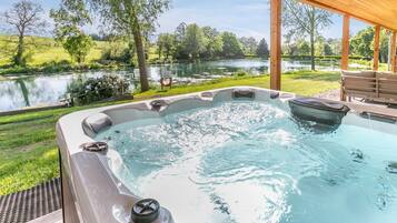 Un bain à remous avec vue sur un lac et la verdure environnante.