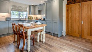 A kitchen with a dining table, chairs, and wooden cabinets. - 2 Bed in Fordingbridge (oc-96125) (Godshill)