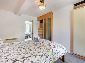 A bedroom with a bed, a wardrobe, and a view of an outdoor seating area. - 1 Bed in Cockermouth (oc-96138) (Buttermere)