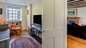 A living room with a TV, sofa, and bookshelves.