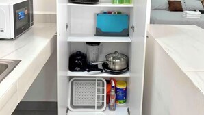 A compact kitchen with a microwave, coffee maker, and storage shelves. - Studio apartment on 5th Avenue, just steps from the beach, the ferry, ADO buses, parks, and more (Playa del Carmen)