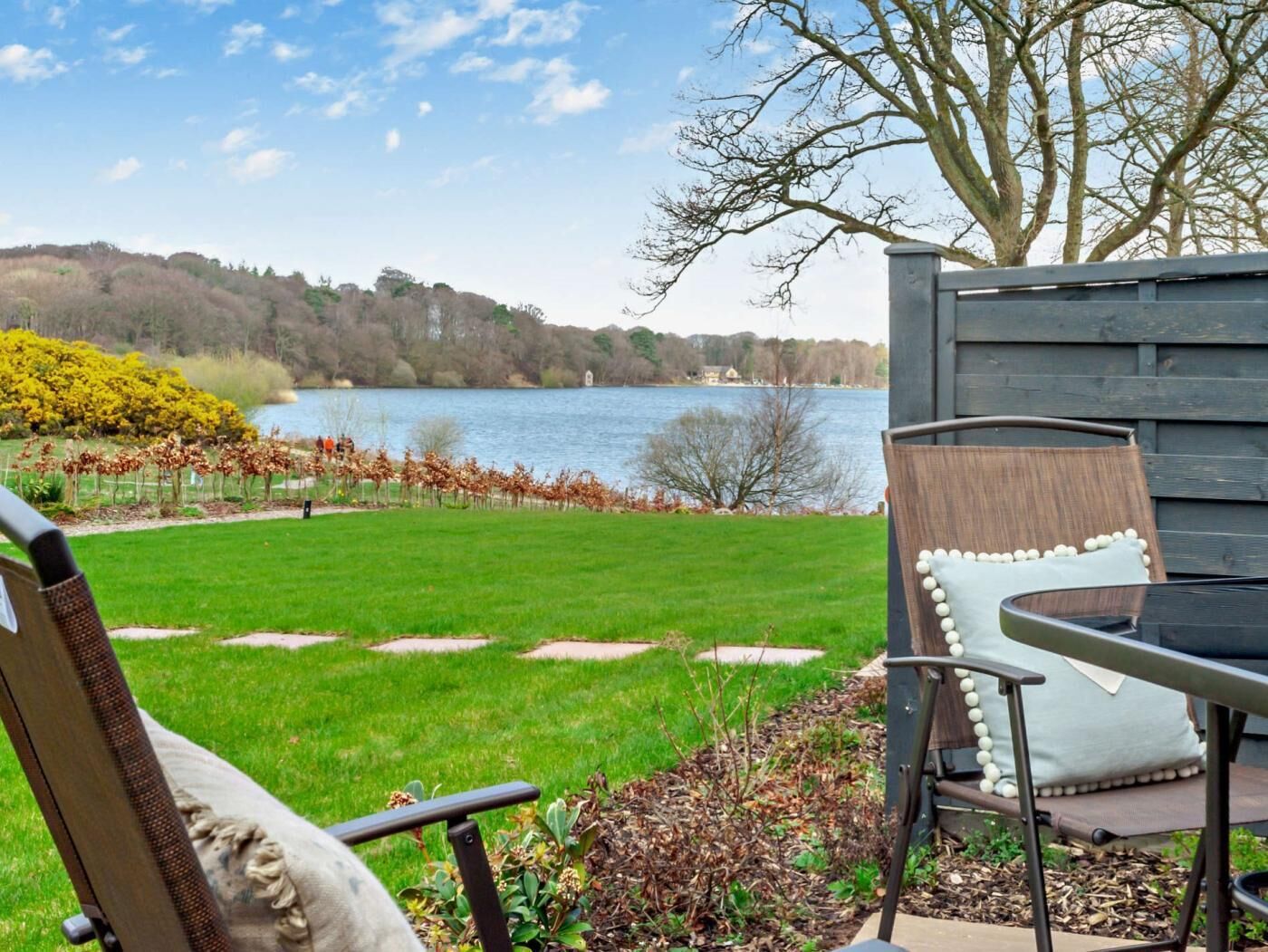 Eine Terrasse mit Seeblick, einem Stuhl und einem Tisch.
