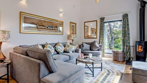 A modern living room with a sectional sofa, a fireplace, and artwork on the walls.