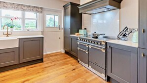 A kitchen with a large stove, a window with a view, and a sink. - 4 Bed in Middlesbrough (oc-96213) (Great Broughton)