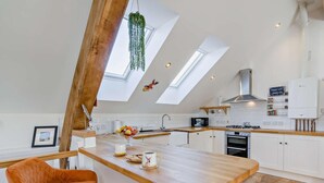 A modern kitchen with a wooden island, white cabinetry, and a skylight. - 1 Bed in Inverkeithing (oc-96221) (Inverkeithing)