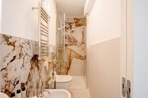 Chuveiro, bidê, toalhas de banho, shampoo