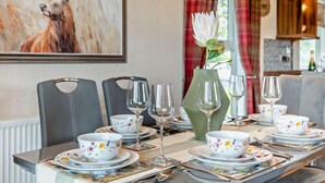 A dining table set with floral-patterned bowls, wine glasses, and cutlery.