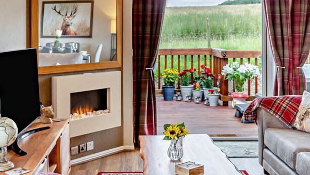 A cozy living room with a fireplace, a television, and a sofa.
