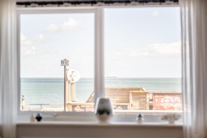 A window with a view of the sea, a wooden deck, and a sign. - 2 Bed in Sandown (oc-96255) (Sandown)