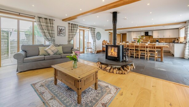 A modern living room with a sofa, coffee table, and fireplace. - 6 Bed in Holsworthy (oc-lympb) (Bradworthy)