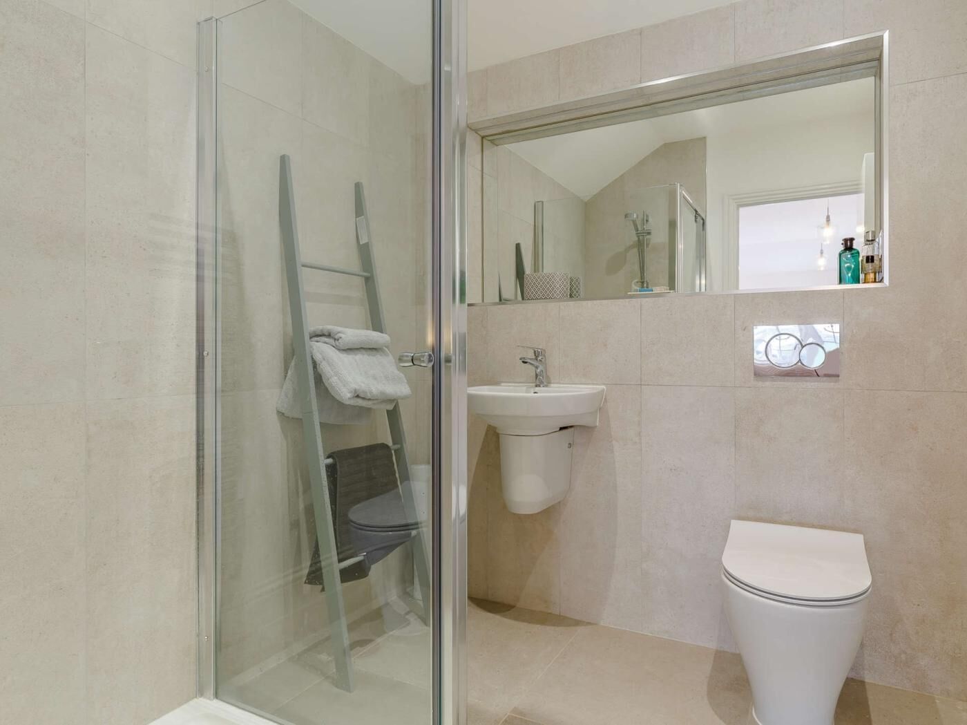 Une salle de bain avec une douche à parois de verre, un lavabo, des toilettes et un miroir.