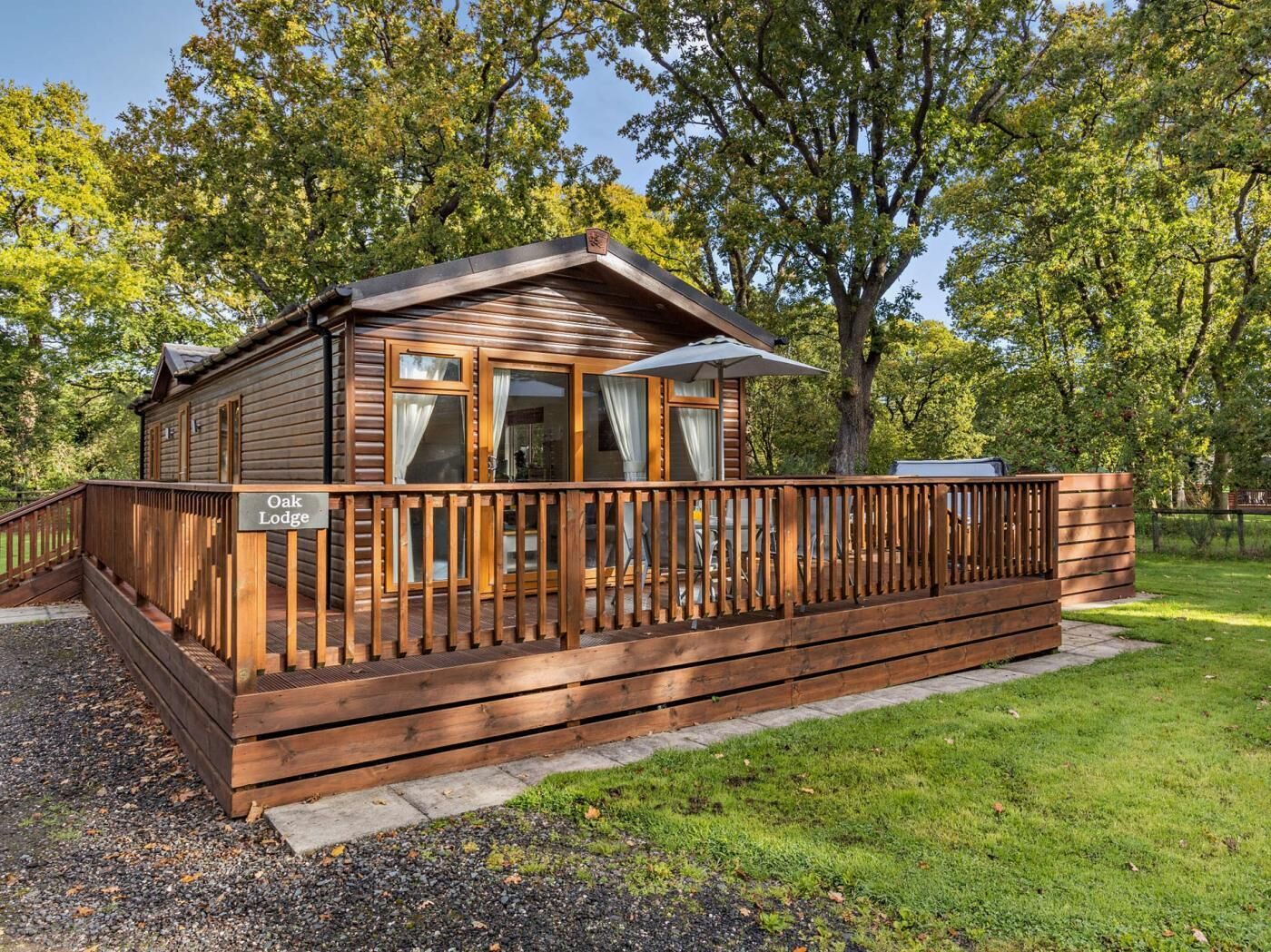 Un chalet en bois doté d’une terrasse, d’un patio couvert et d’une enseigne indiquant « Oak Lodge ».