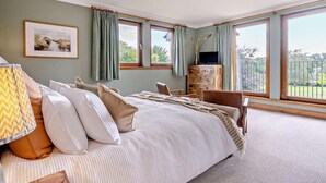 A bedroom with a bed, a TV, a desk, and large windows. - 6 Bed in Perth (oc-96289) (Stanley)