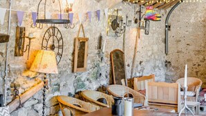 A rustic interior with stone walls, wooden beams, and various antique furniture. - 3 Bed in Carnforth (oc-96319) (Yealand Redmayne)