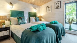 Ein Schlafzimmer mit zwei Betten, Holzboden und einem Fenster mit Blick.