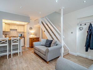 A modern interior with a kitchen, dining area, and living room, featuring a staircase and a coat rack. - 1 Bed in Keswick (oc-96314) (Keswick)