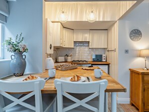 A modern kitchen with white cabinetry, a wooden island, and pendant lighting. - 1 Bed in Keswick (oc-96314) (Keswick)