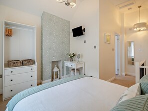 A bedroom with a bed, a dresser, a vanity, a television, and a hallway. - 1 Bed in Keswick (oc-96314) (Keswick)