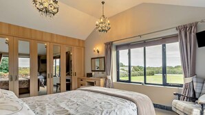 A bedroom with a large bed, a desk, a chair, and a wardrobe. - 2 Bed in Bude (oc-96290) (Poundstock)