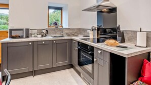 A modern kitchen with a large island, built-in oven, and a skylight. - 1 Bed in Pickering (oc-96309) (Allerston)