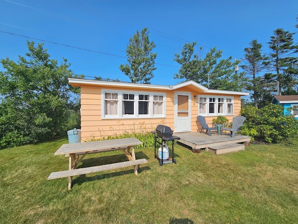 A single-story house with a porch, two windows, and a door. - Lyons Cottages - Cottage #8, 2BR Walk to the Beaches of Stanhope National Park! (Stanhope)