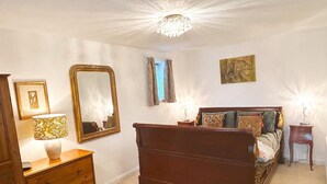 Ein Schlafzimmer mit einem hölzernen Bett, einem Schminktisch, einem Spiegel und einer Chandelier.