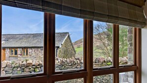 A room with large windows overlooking a stone wall and a traditional building. - 1 Bed in Brecon (oc-96359) (Cantref)