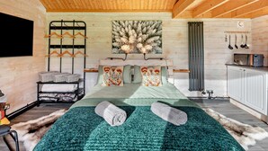 Interior em madeira com uma cama, televisão na parede e um radiador.