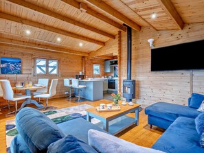A cozy cabin interior with a dining area, kitchen, and living room.