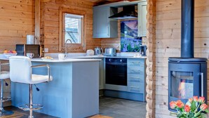 A cabin kitchen with a central island, a stove, and a window. - 2 Bed in Middlesbrough (oc-96344) (Skutterskelfe)