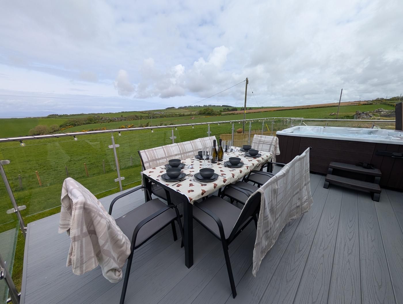 A table set outdoors with a hot tub and a scenic view.
