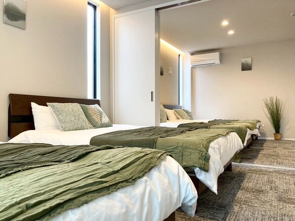 Ett hotellrum med två sängar, en stor spegel och en luftkonditioneringsanläggning.