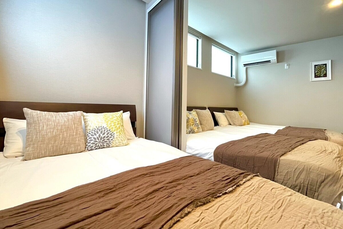 Quarto de hotel com duas camas, um espelho grande e um aparelho de ar condicionado.